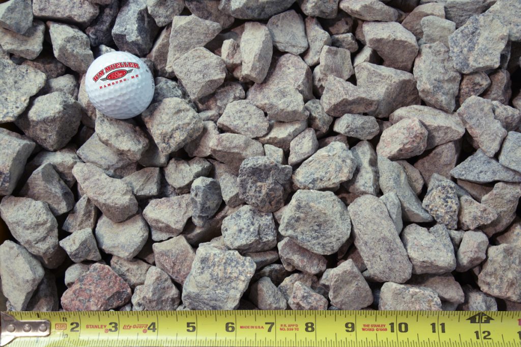 granite rock shown with a measuring tape and golf ball for size comparison