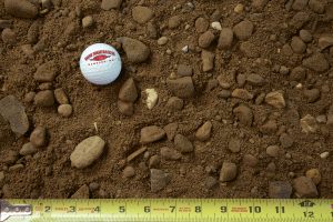 Class 5 gravel shown with a measuring tape and golf ball for size comparison
