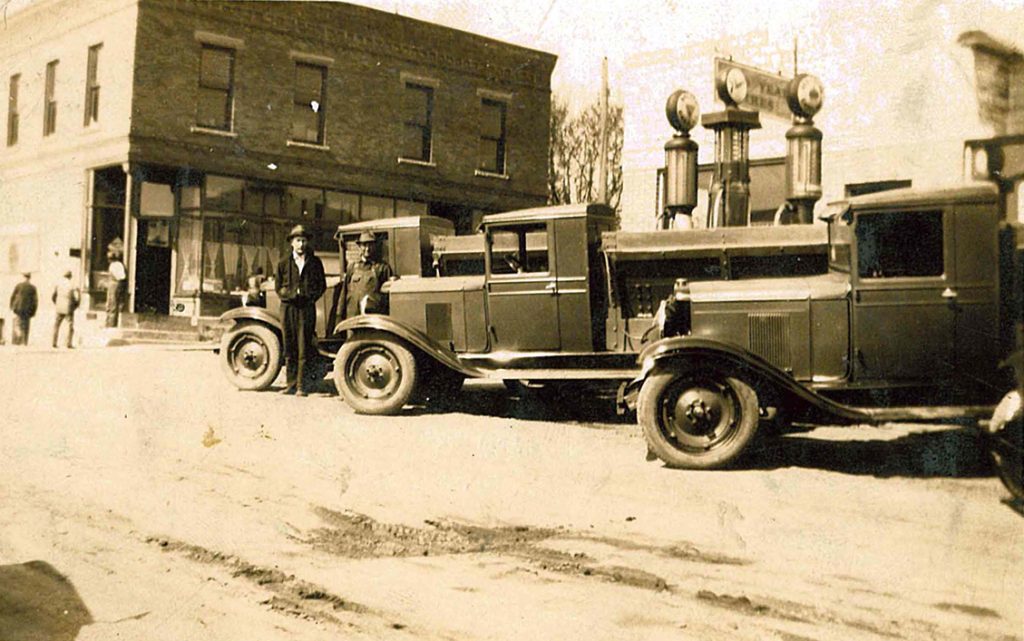 Wm. Mueller and Sons historic 1920's photo—Wm. Mueller Trucks outside of a gas station