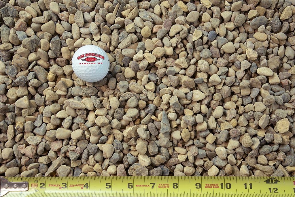 roofing rock with golf ball and measuring tape for size comparison