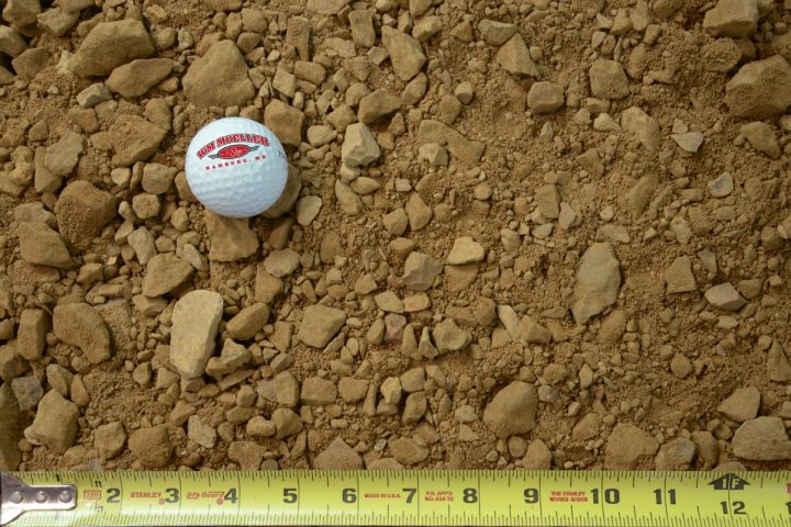 1" minus limestone clear shown with a measuring tape and golf ball for size comparison