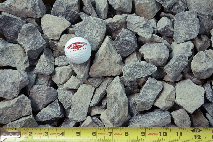 trap rock shown with a measuring tape and golf ball for size comparison